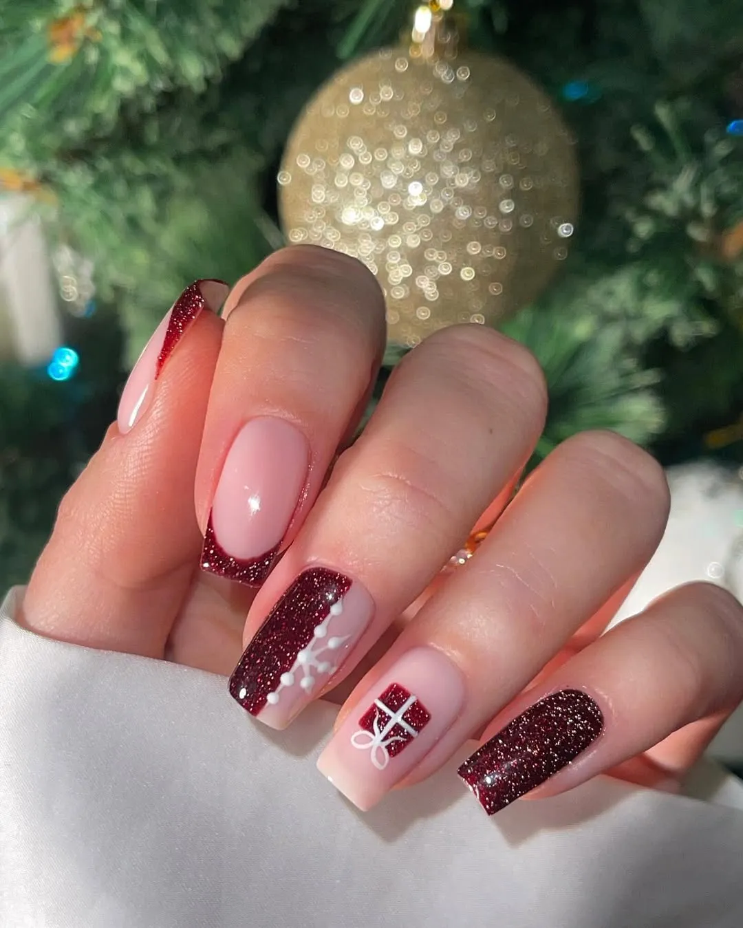Dark red shimmery polish with french tip designs, as well as gift wrapped presents and snowflakes