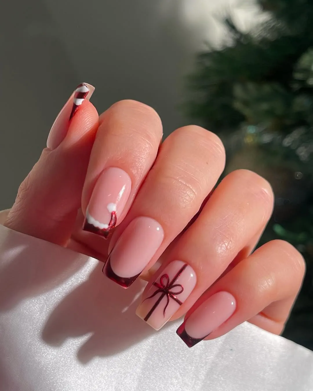 Metallic red french tips with a Santa Claus hat design