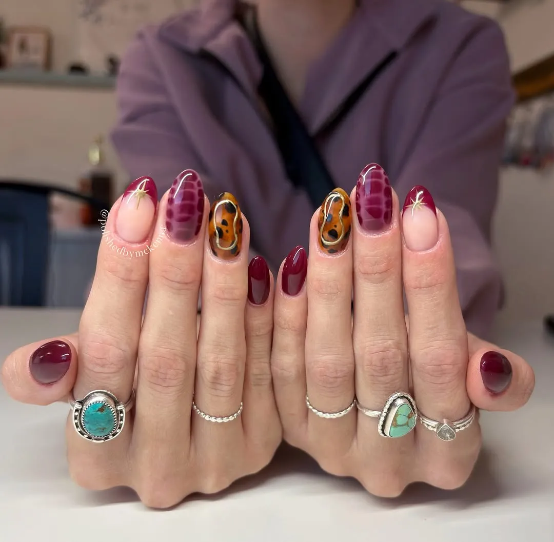 Maroon nails with tortoise and snakeskin designs nails, plus french tips with stars on the line