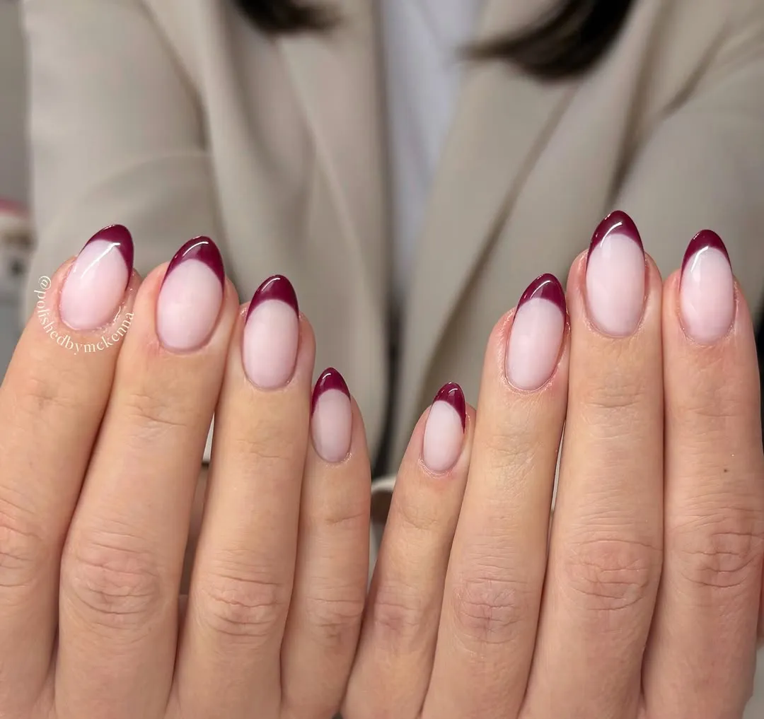 Maroon french tips with an almond shaped nail