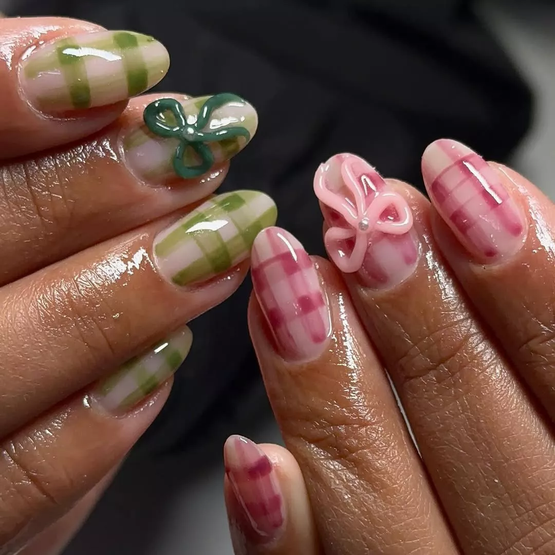 Person with green and pink gingham nails with matching bows on each middle finger