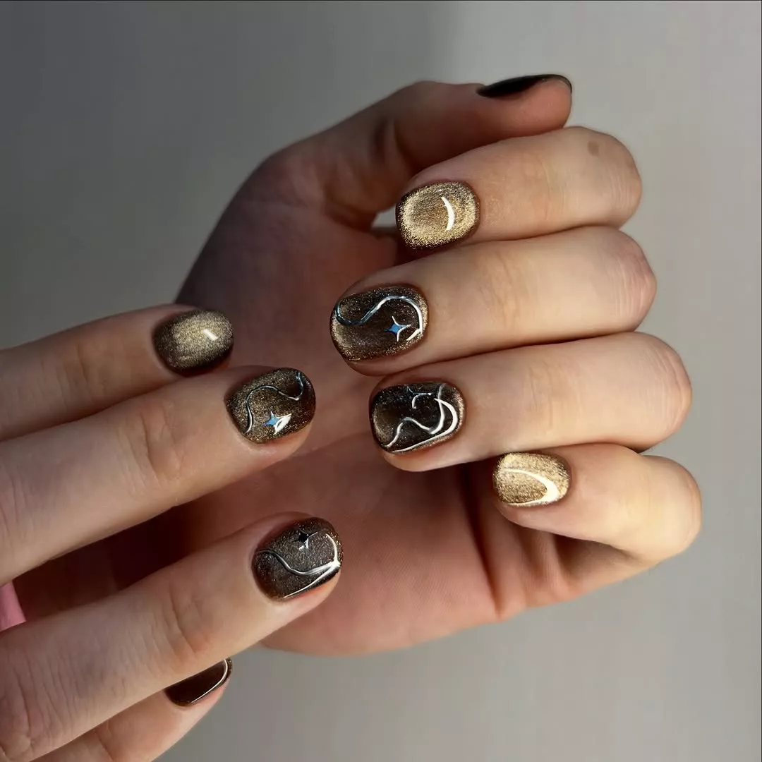 Person with short, square-oval nails that have metallic accents on four fingers