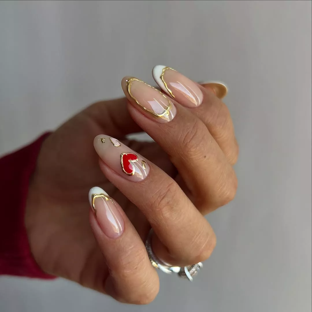metallic nails with French tips, hearts, and gold accents on each