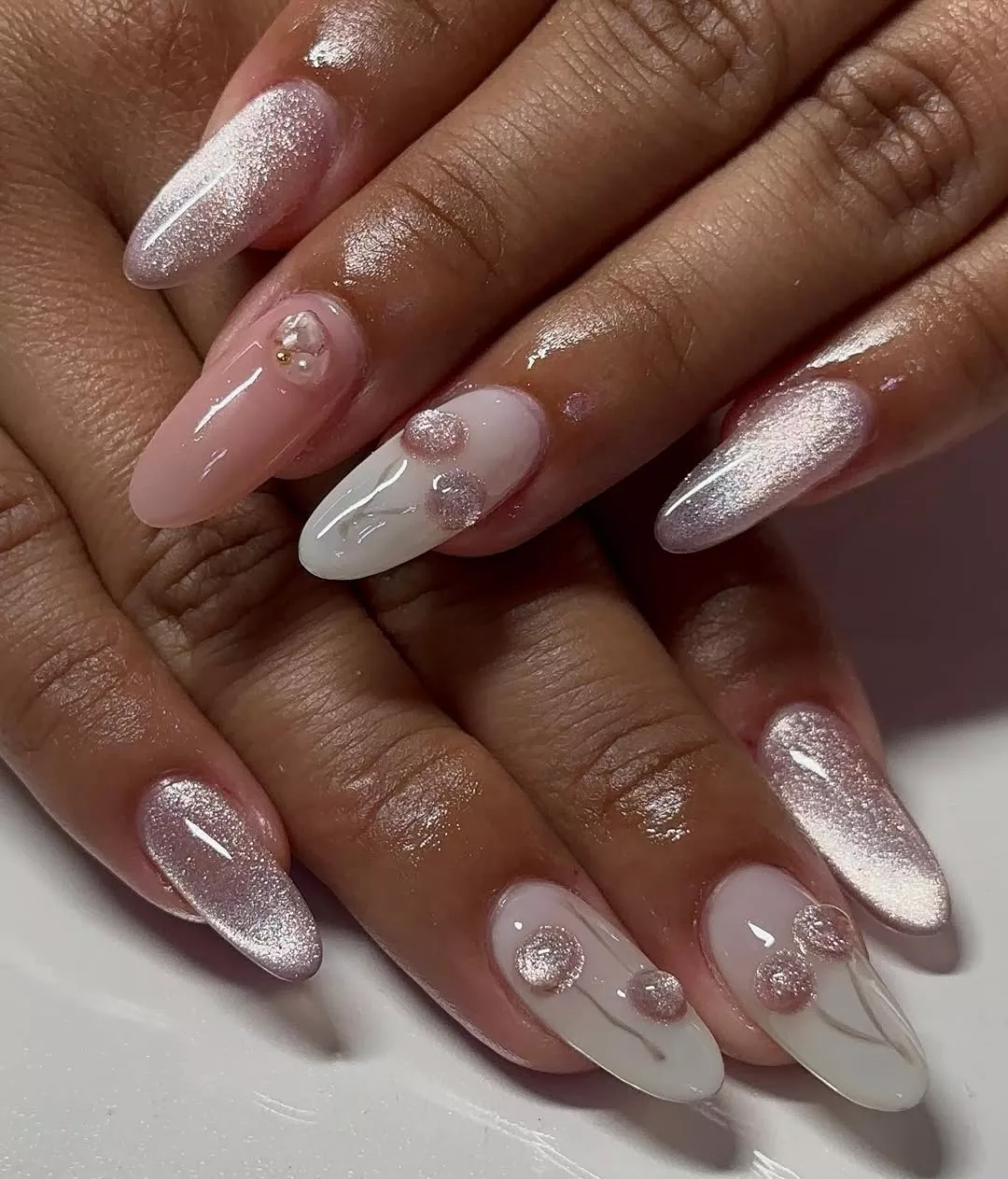 Person with a round, velvet-looking manicure featuring 3D cherries