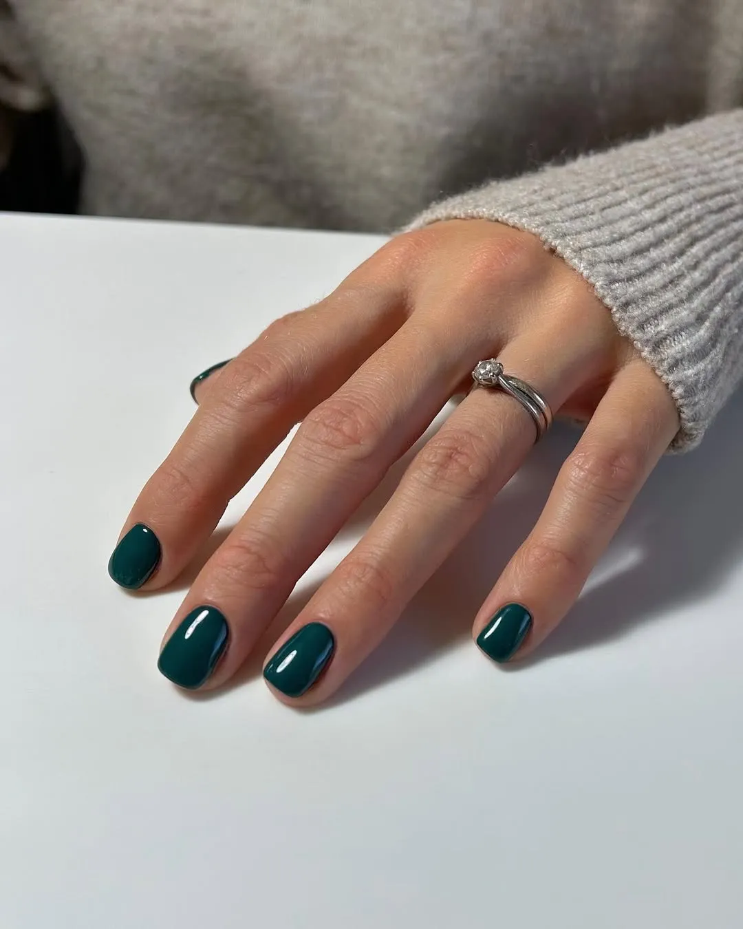 A person showing off a deep green manicure