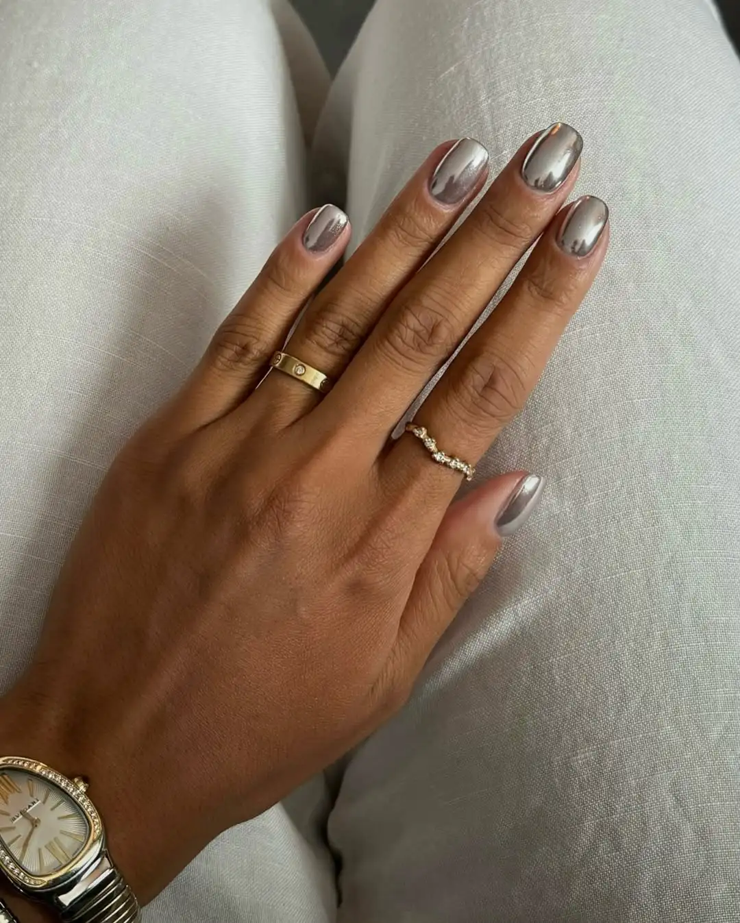 A person showing off a silver chrome manicure