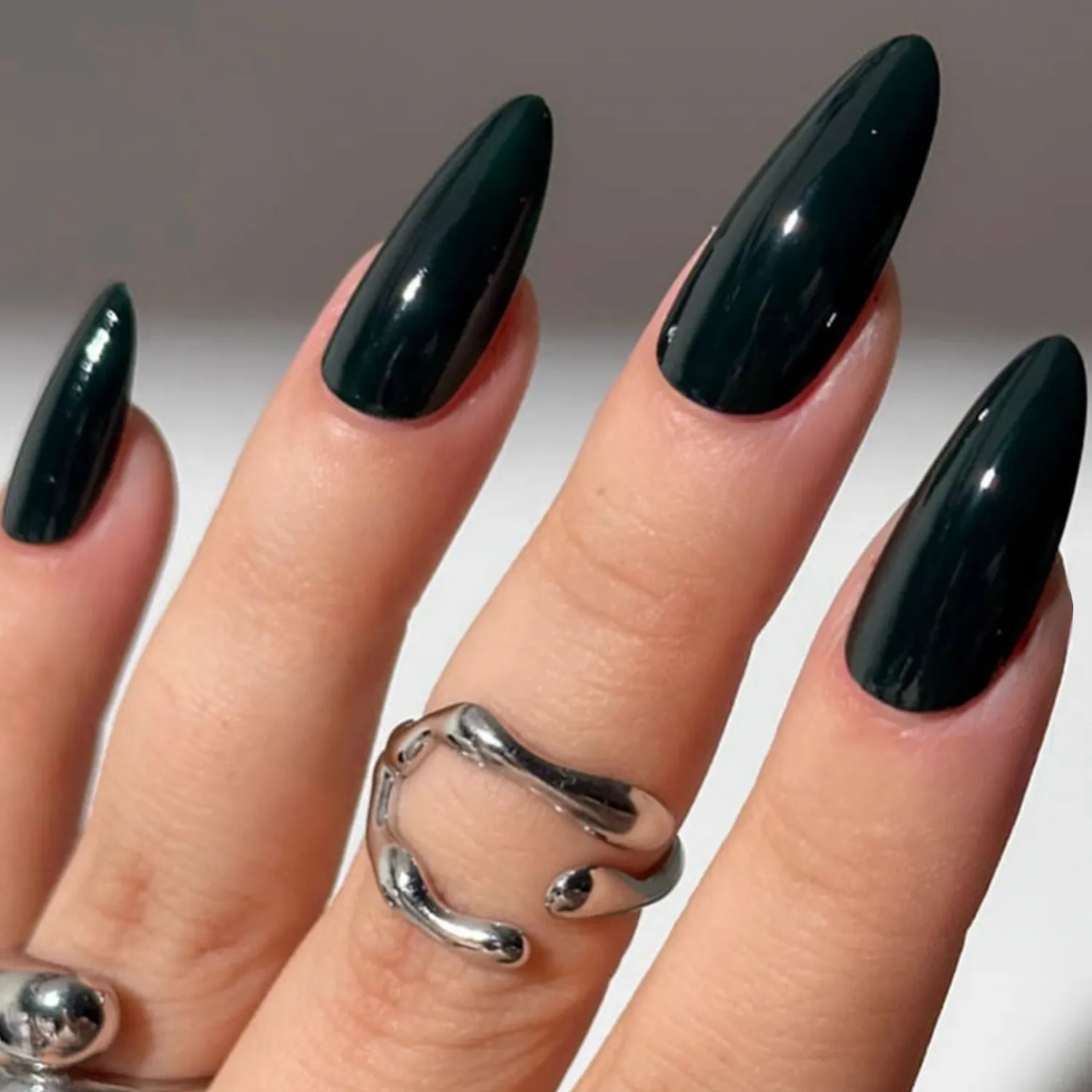Hand with long pointed manicured nails and silver rings