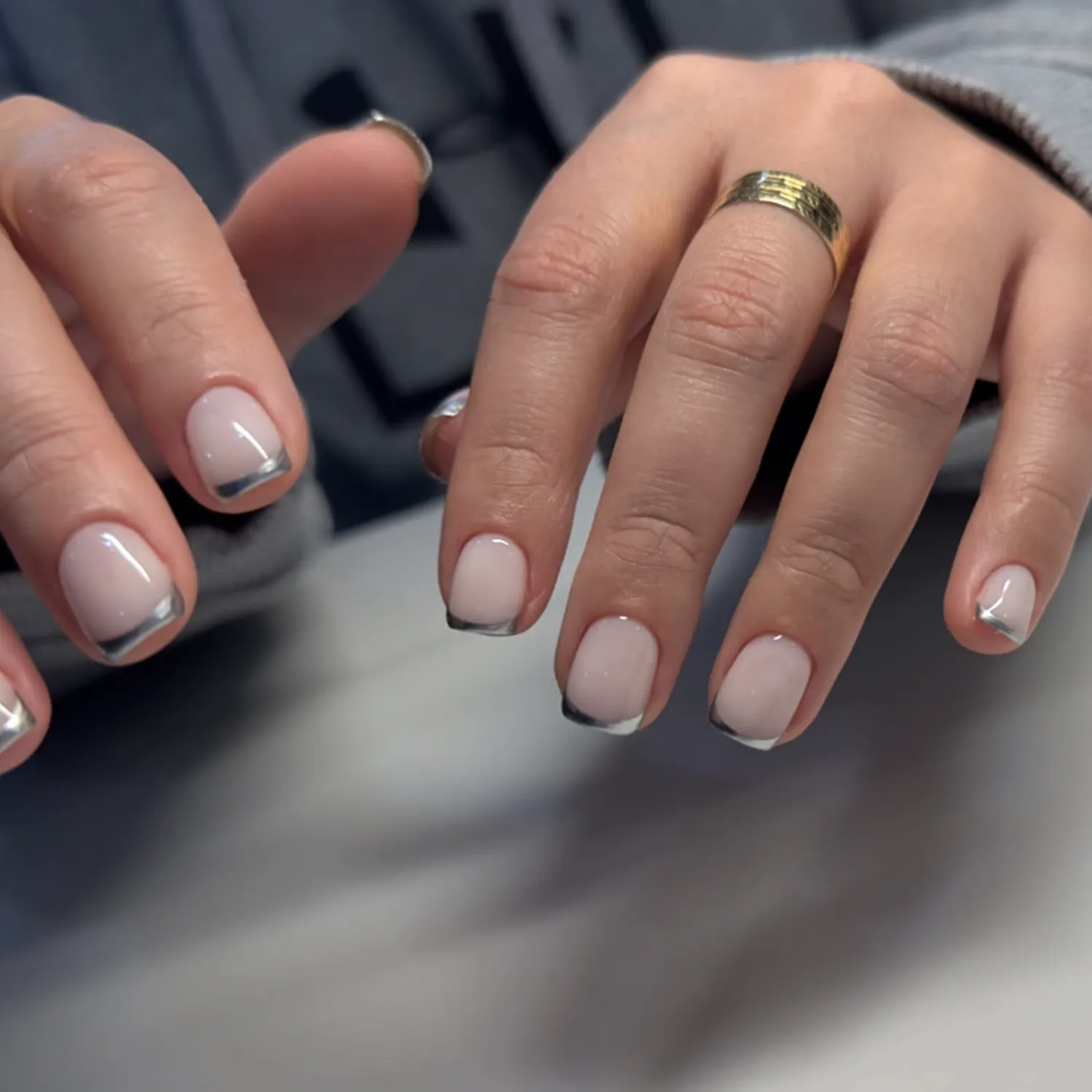 Manicured hands with a metallic and polished nail design