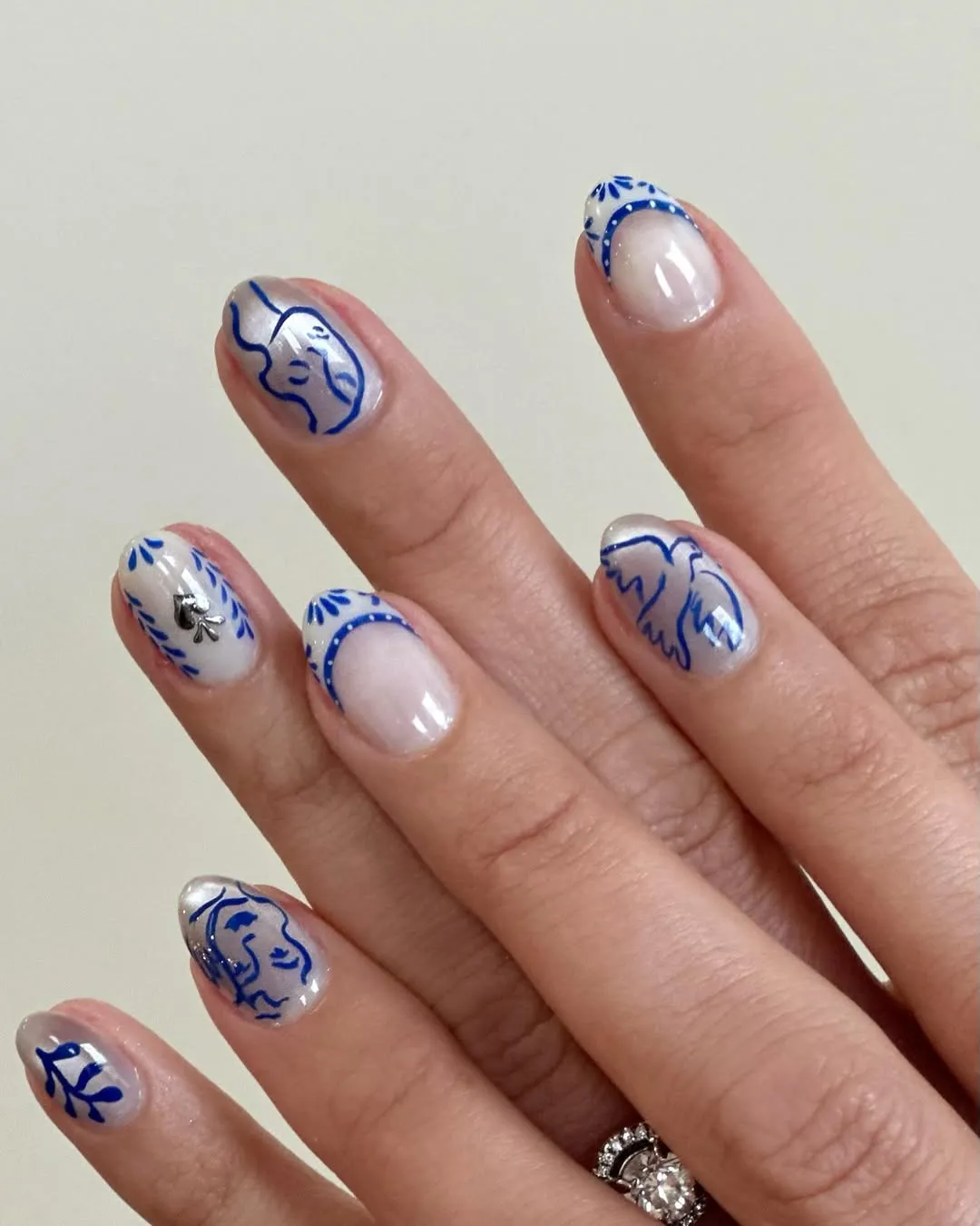 A person showing off a manicure with blue details