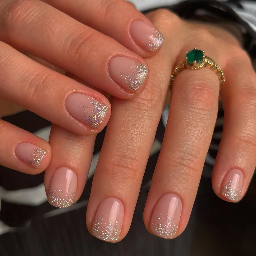 A person showing off a silver sparkle manicure