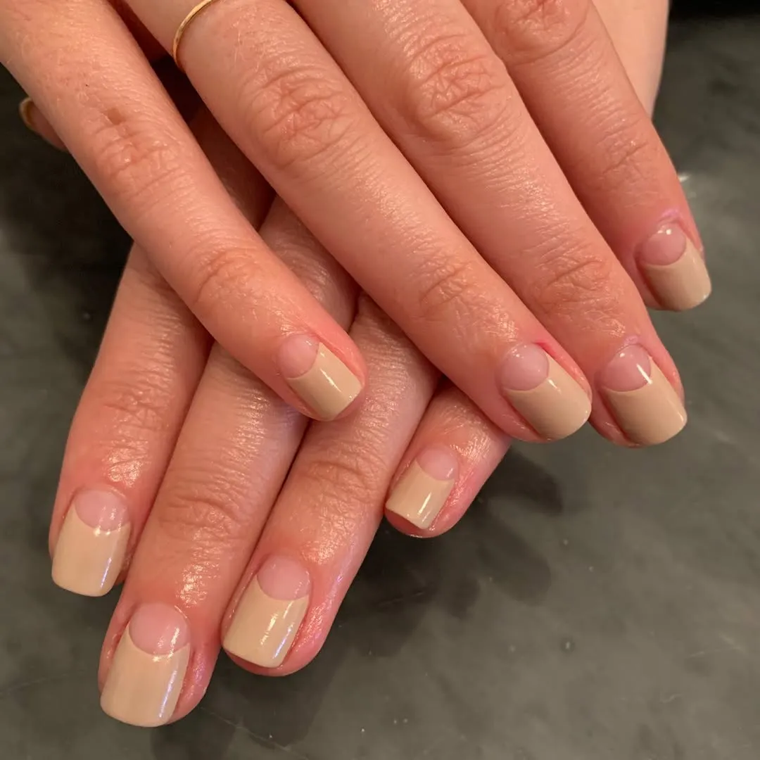A person showing off a reverse nude French manicure