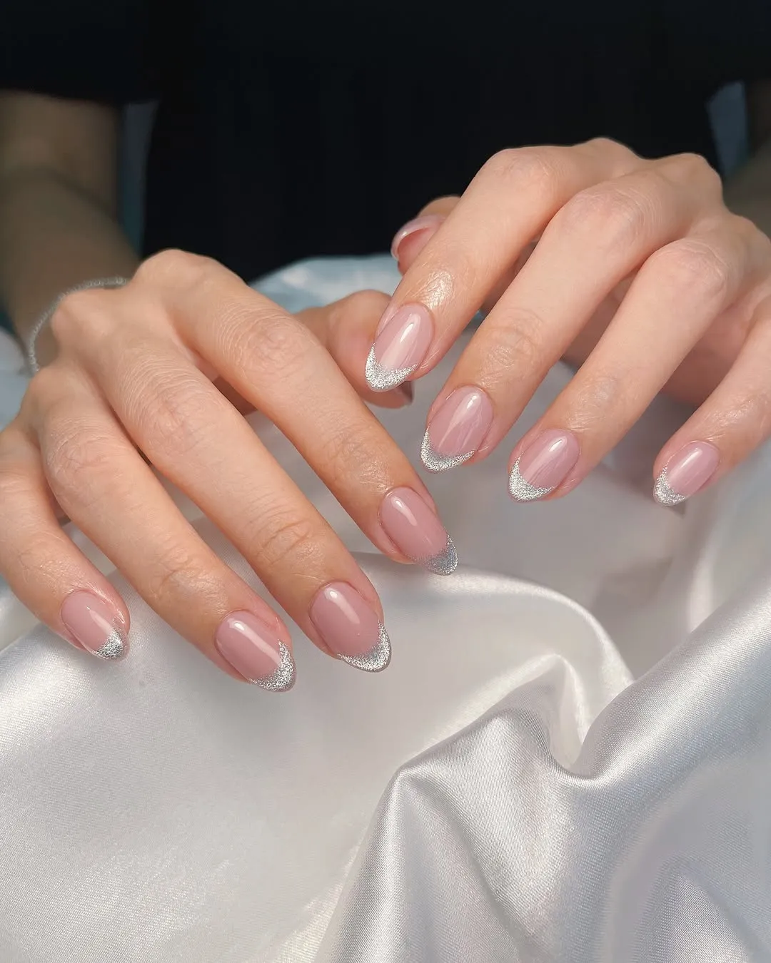 A person showing off a silver cat-eye manicure