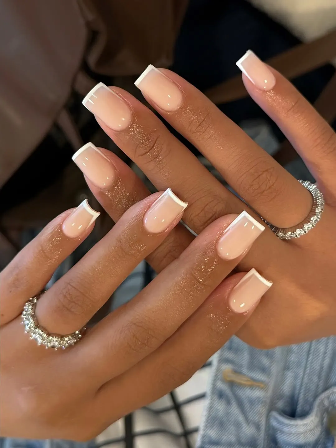 A person showing off a square French manicure