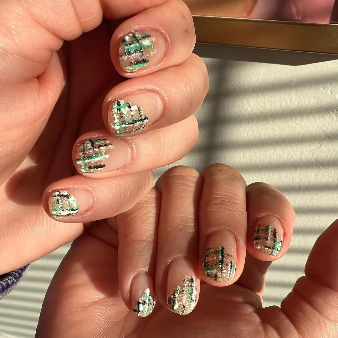 A person showing off a tweed tipped manicure