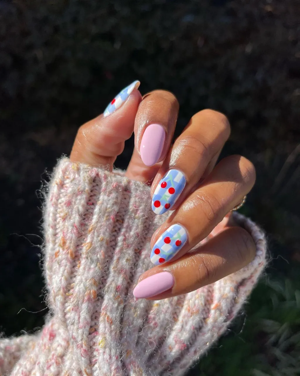 blue gingham almond shaped nails with a cute red cherry nail design