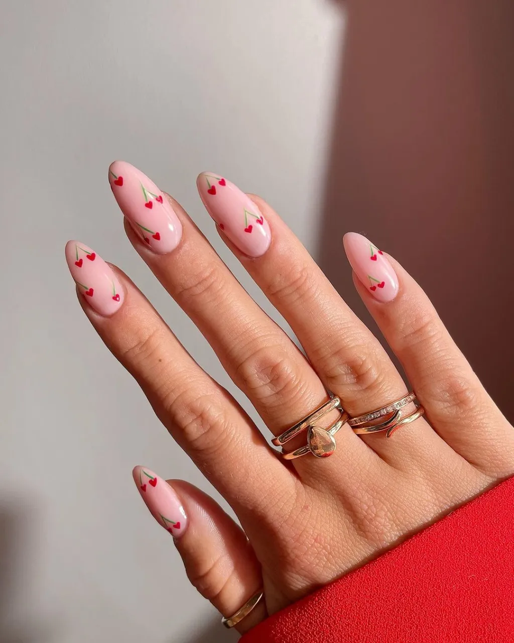 cute simple almond shaped manicure with a red heart cherry nail design