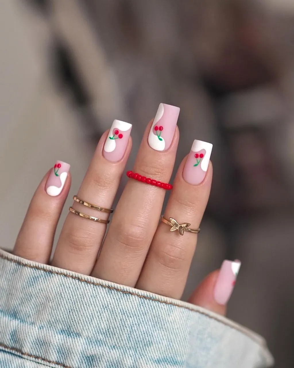 cute coffin shaped red cherry nails with white swirl designs