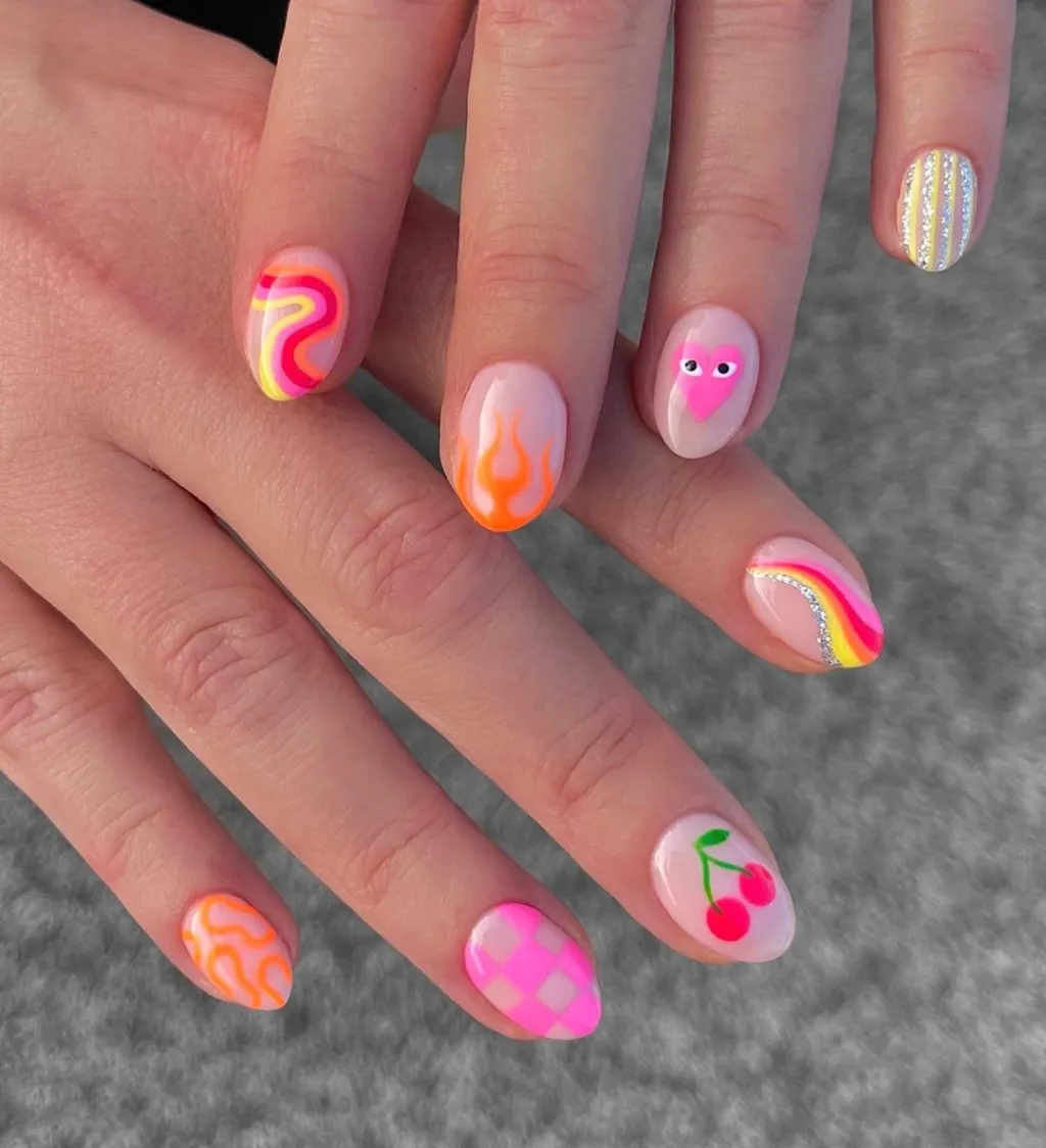 mismatched pink red and orange manicure with fruit and checkerboard and swirl designs