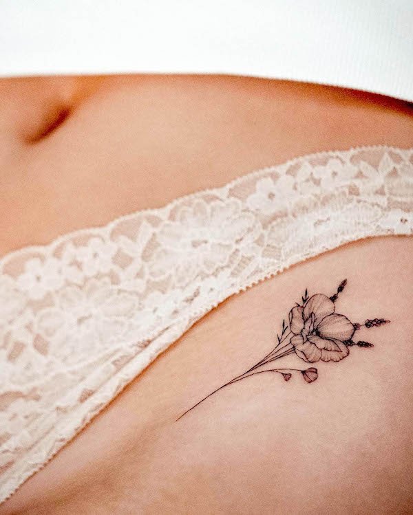 Small flower hip tattoo by @bunami.ink