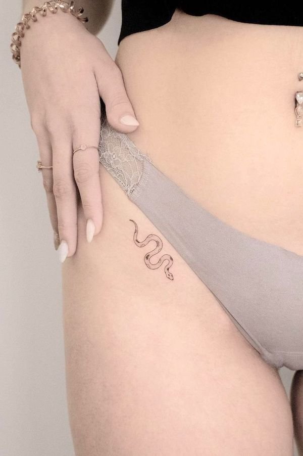 Tiny snake hip tattoo by @jk.tattoo