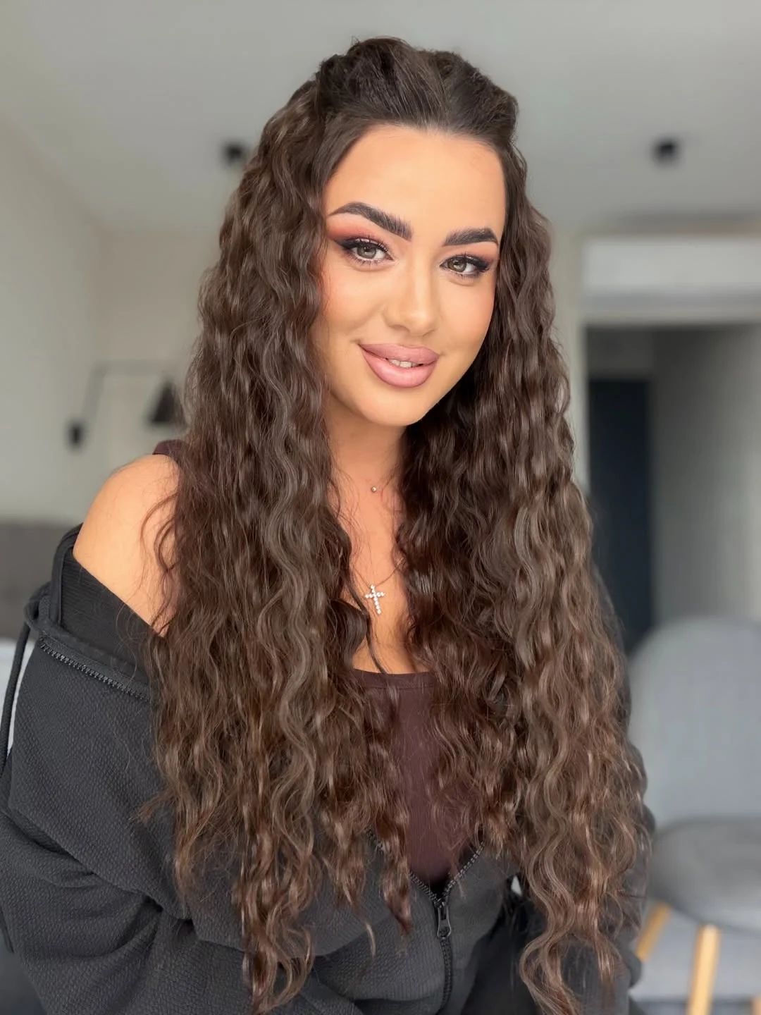 Close-up of a smiling woman with voluminous, natural summer hair curly ideas 2026, styled with a soft side part.