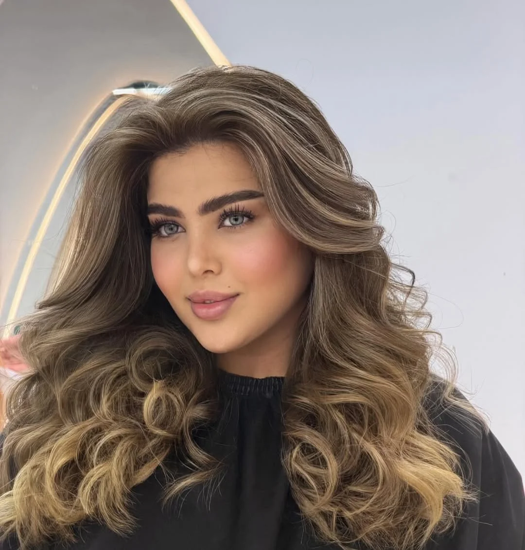 Close-up of a woman with vibrant pink and purple ombre hair, styled in loose waves, showcasing summer hair cute colors 2026. Perfect for a fun, festival look.