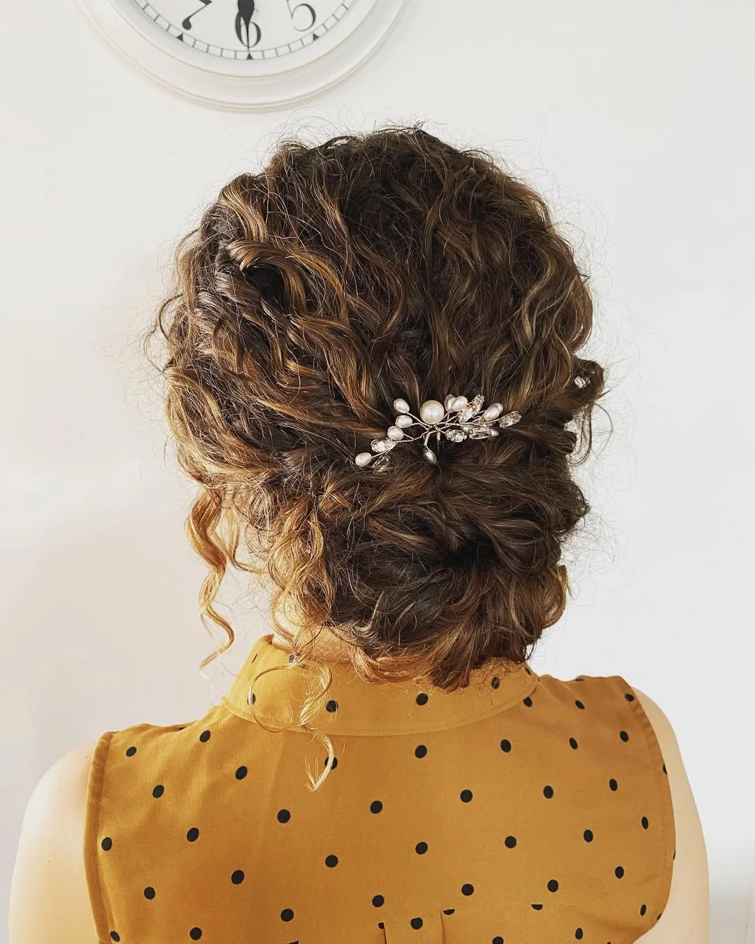 Close-up of a woman with voluminous, bouncy brown curls, showcasing beautiful summer hair curly ideas 2026. Her hair is perfectly styled, framing her face softly.